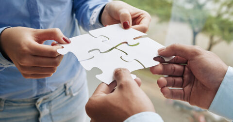 Close-up image of business people assembling puzzle